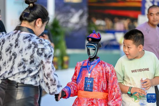 8月29日，观众在第五届中蒙博览会内蒙古展区和机器人工作人员握手。新华社记者 连振 摄
