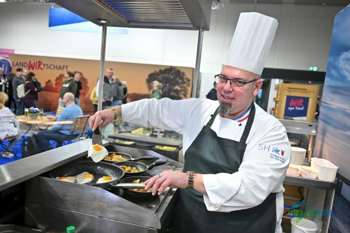 石勒苏益格-荷尔斯泰因展位上，厨师正在制作本地食材烹制的特色菜肴。